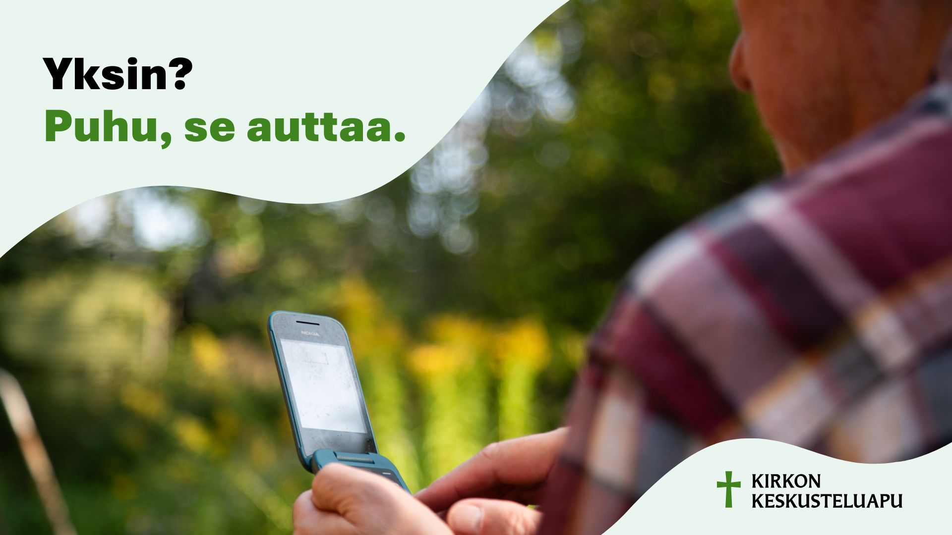 Kirkon keskusteluavun mainos, jossa ruutupaitainen näplää kännykkää kesäisessä maisemassa.
