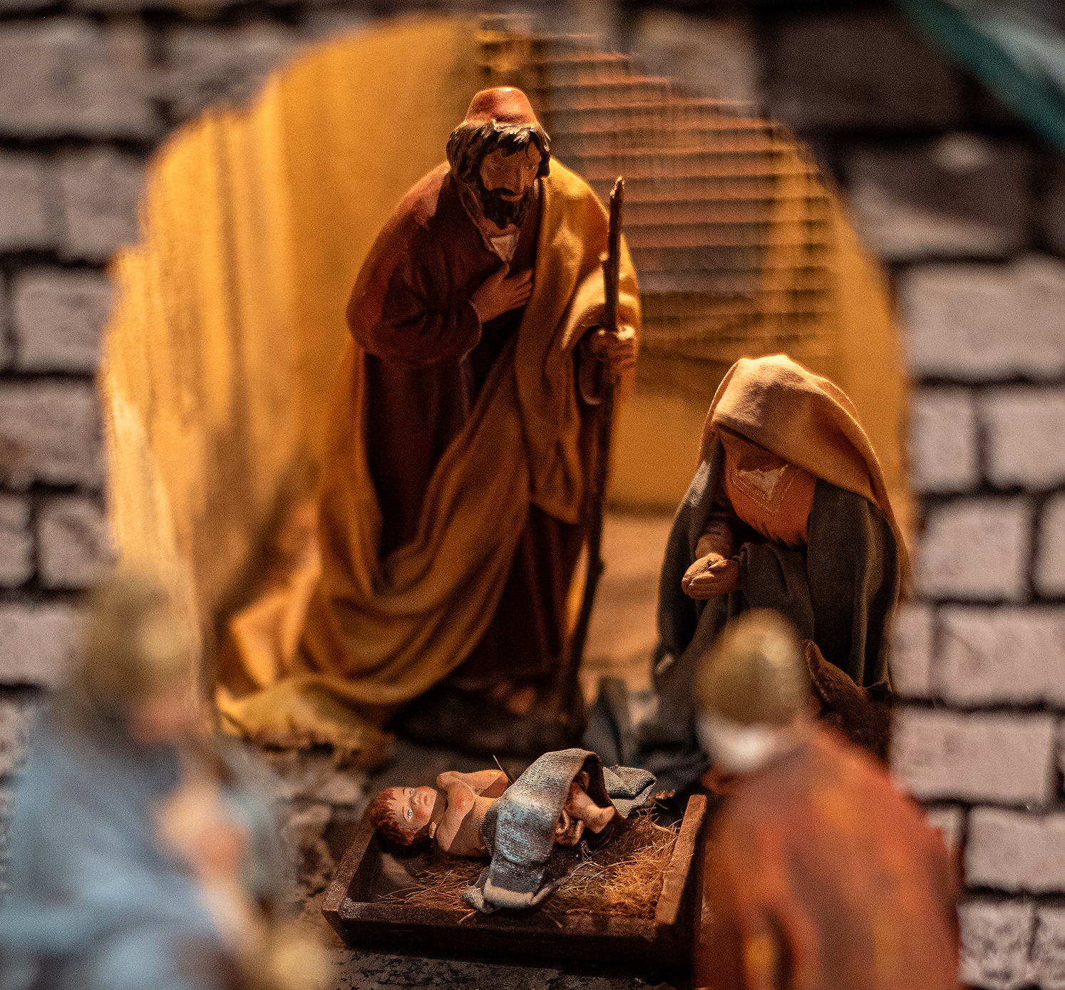 Jeesus-lapsi makaa seimessä Marian ja Josefin katseiden alla.