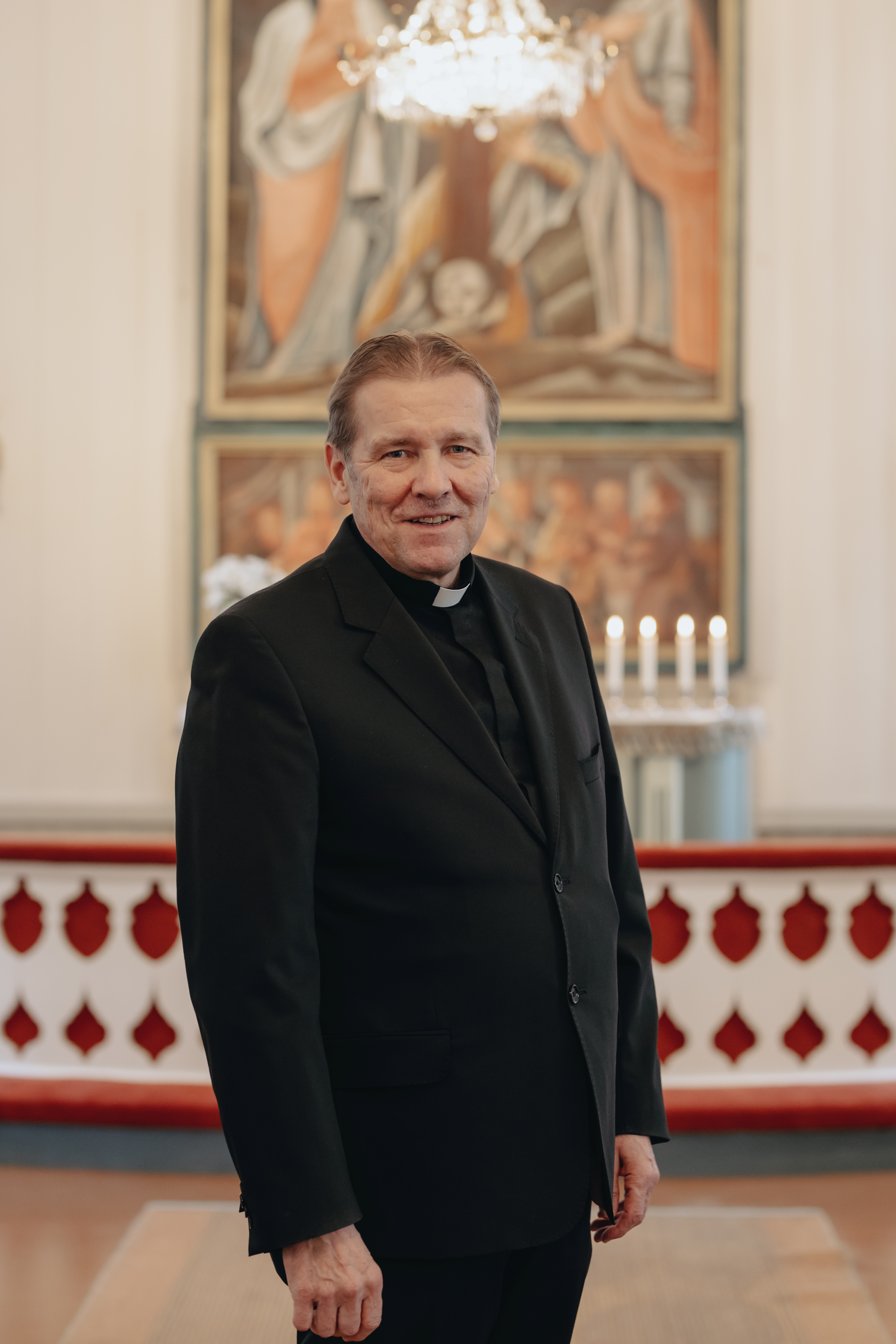 Kirkkoherra Juha Karhulahti kirkkosalin keskellä kuvattuna.