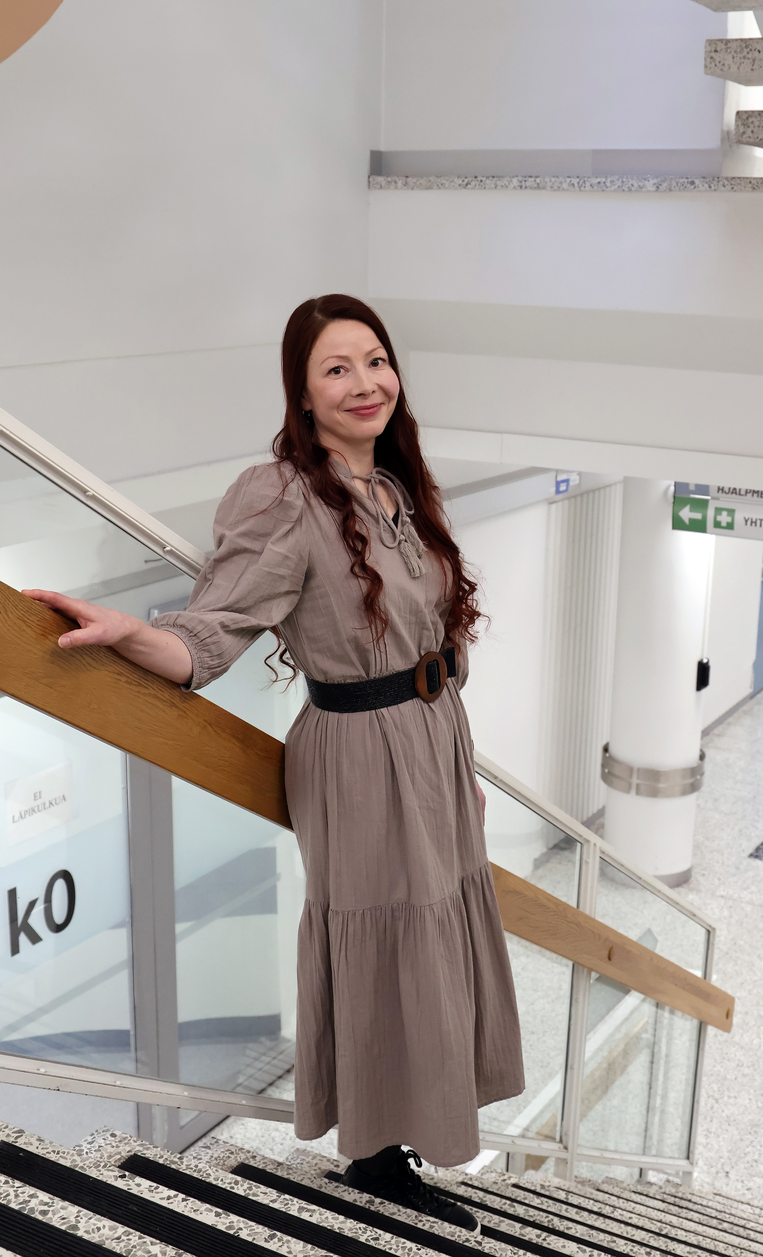 Heidi Hietalahti nojaa kaiteeseen sairaalan portaikossa.